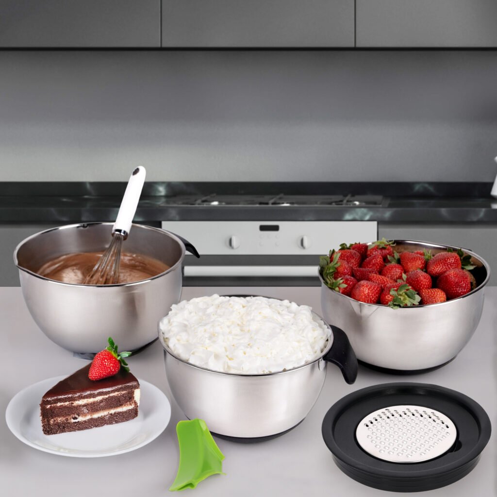 Stainless steel mixing bowl set with lids, strainer attachment, and grater inserts arranged together