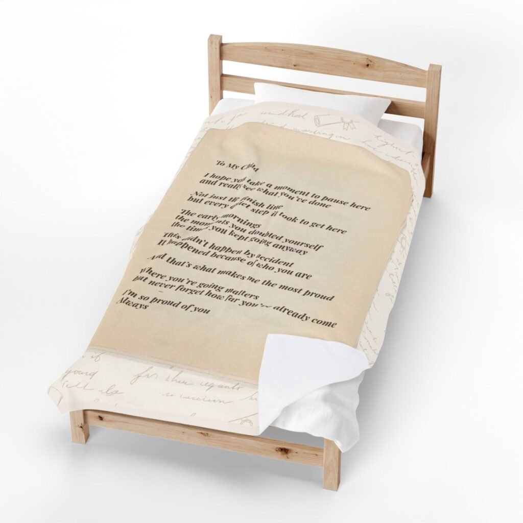 Letter blanket with proud message design displayed on bed in warm neutral tones